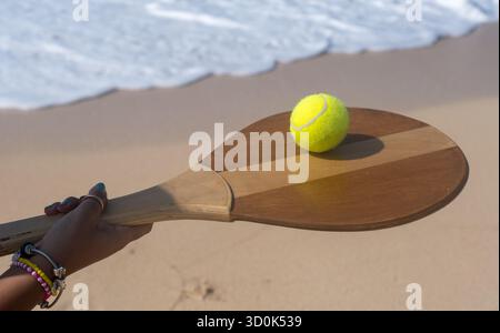 La donna regge raquet e palla sulla spiaggia in estate, in Egitto Foto Stock