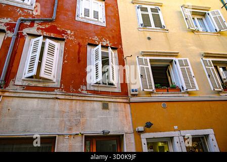 Affacciato su finestre con persiane che si affacciano sulla piazza della città costiera di Muggia, l'unica città portuale d'Italia sul mare Adriatico Foto Stock