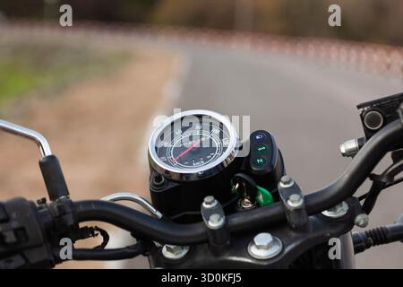 Vista del manubrio e del tachimetro della motocicletta. Vista sulla strada da una motocicletta d'epoca. Sfondo a tema bici. Foto Stock