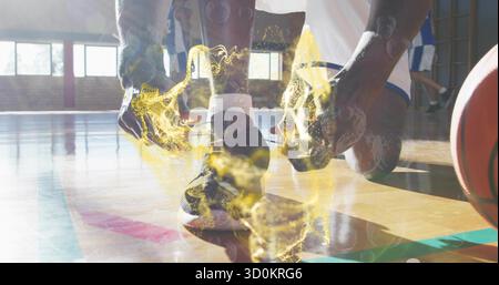 Pallacanestro con lacci in uniforme sul campo da palestra, con aura brillante intorno a scarpa e basket Foto Stock