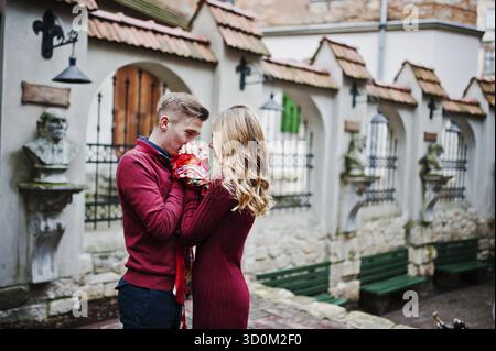Giovane bella elegante moda giovane in un abito rosso nella storia di amore alla città vecchia Foto Stock