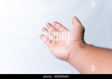 Foto ravvicinata della mano aperta di un uomo, palma in alto, che si avvicina come se chiedesse, ricevesse o offrisse qualcosa. Isolato su uno sfondo bianco pulito Foto Stock