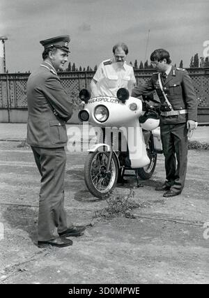 DEU, Germania, Berlino, 1990-03-18: I poliziotti di Berlino Ovest e Est si incontrano sul ponte Behmstrassenbruecke al confine tra il distretto occidentale di Wedding e il distretto orientale di Prenzlauer Berg. Una pattuglia motociclistica della polizia popolare mostra a un poliziotto di Berlino Ovest la sua moto, in primo piano un membro delle truppe di frontiera della RDT. [traduzione automatizzata] Foto Stock