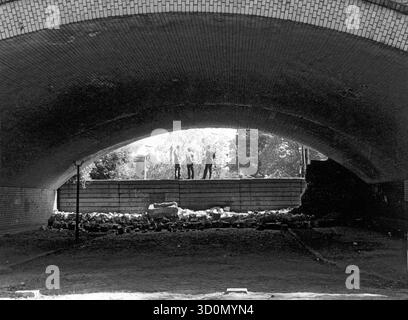 DEU, Germania, Berlino, 1990-03-18: Demolizione del muro sotto le piattaforme Della S-Bahn alla stazione di Wollankstrasse. La gente sta sui resti del muro e guarda verso est. Vista da ovest attraverso l'arco del viadotto. [traduzione automatizzata] Foto Stock