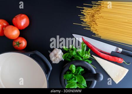 vista dall'alto degli ingredienti per la pasta italiana su un tavolo in pietra scura Foto Stock