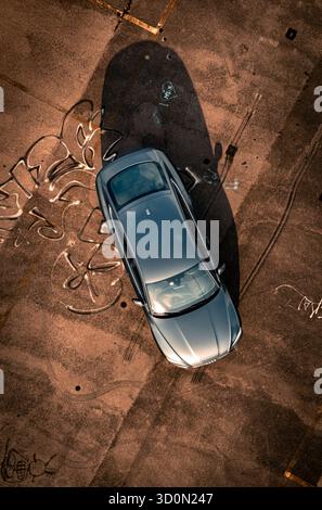 Colpo di droni di un'auto da una vista dall'alto sul tetto di un parcheggio Foto Stock