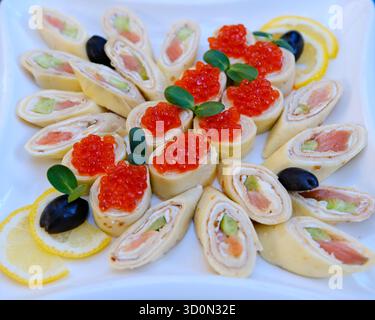 Panini di pancake sottili con salmone affumicato, crema di rafano e foglie di rucola. Foto di alta qualità Foto Stock