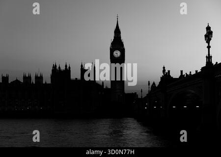 Sagoma del Palazzo di Westminster e del Big Ben con riflessi sul Tamigi al tramonto. Foto Stock