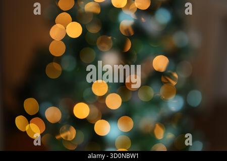 Le luci bokeh dorate si illuminano dolcemente e lo sfondo astratto perfetto per le festività natalizie o natalizie Foto Stock