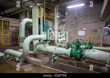 Itaipu Binacional, Brasile - 22 giugno 2025: Rete complessa di tubi e valvole di controllo verdi all'interno della diga di Itaipu, vicino all'unità turbina U14. Foto Stock
