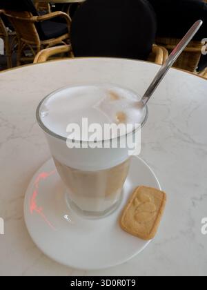 Un caffè da latte con schiuma di latte in una tazza di vetro trasparente Foto Stock