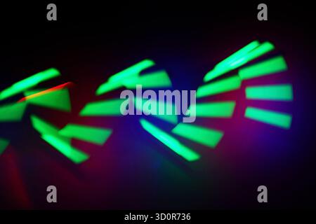 Sequenze di luce al neon. Immagine astratta di dinamiche tracce di luce verde su sfondo scuro. Foto Stock