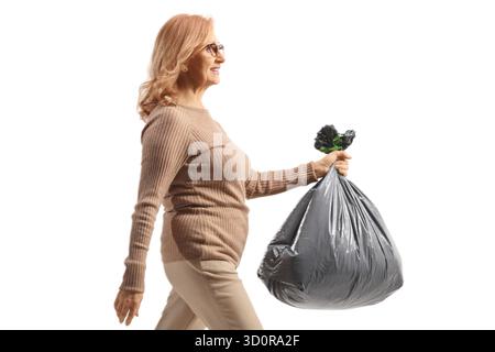 Donna di mezza età che trasporta un sacchetto per rifiuti di plastica isolato su sfondo bianco Foto Stock