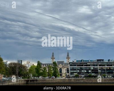 La storica torre dell'orologio e il moderno complesso a più piani si innalzano sopra una passeggiata lungo il lungomare di Puerto Madero a Buenos Aires, Argentina Foto Stock