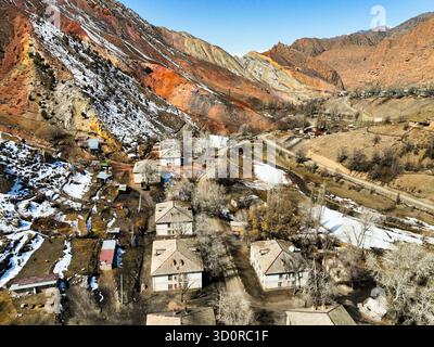Ming-Kush, Kirghizistan - 13 ottobre 2024: Veduta aerea degli edifici residenziali dell'epoca sovietica abbandonati nel remoto villaggio sullo sfondo della vibra Foto Stock