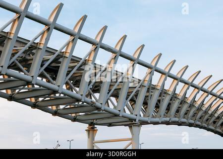 Moderna struttura a ponte in acciaio con design geometrico sullo sfondo del cielo. Foto Stock