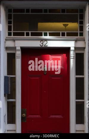 Porta anteriore rossa con finestra sullo specchio di poppa e bulloneria in ottone a Beacon Hill, Boston Foto Stock