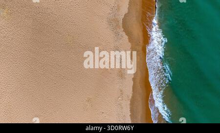 vista aerea delle onde che si infrangono sulla spiaggia sabbiosa Foto Stock