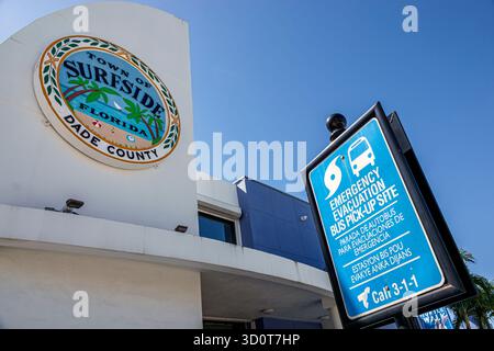 Surfside Miami Florida, città di Surfside edificio municipale SEAL Dade County, evacuazione di emergenza autobus punto di prelievo segno bilingue inglese spagnolo creolo Foto Stock
