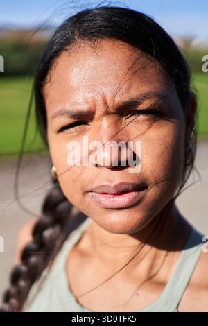 Primo piano di una donna millennial africana in abbigliamento sportivo all'aperto con grande serietà Foto Stock