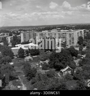 Una vista panoramica ad alto angolo che si affaccia su Sloviansk, Ucraina, presa da un edificio di 14 piani in via Svobody (via della libertà) nel luglio 1997. Questa foto d'archivio in bianco e nero mostra il netto contrasto tra la grande area di basse case private ("chastnyy sektor") con giardini e gli edifici a più piani dell'era sovietica sullo sfondo (compresa la Scuola N. 1). Questa immagine nostalgica cattura il tipico paesaggio urbano misto di una città post-sovietica negli anni '1990 Un prezioso documento sulla vita pacifica nel Donbas prima della guerra. Foto Stock