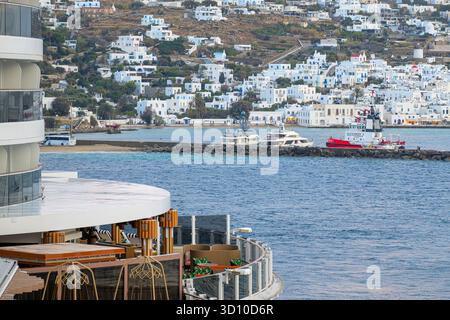 Ammira da una lussuosa nave da crociera in mare il villaggio dipinto di bianco di Mykonos, in Grecia, mentre le luci si accendono in prima serata. Foto Stock