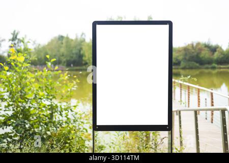 Mockup verticale vuoto per cartelloni pubblicitari vicino al lago nel parco naturale Foto Stock