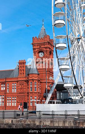 Cardiff, Galles - 14 agosto 2022: Lo storico Pierhead Building rosso e la ruota panoramica nella baia di Cardiff in una giornata estiva di sole Foto Stock