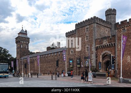 Cardiff, Galles - 15 agosto 2022: Castello di Cardiff storica fortezza con torre dell'orologio in pietra e mura difensive esterne sotto un cielo estivo parzialmente nuvoloso Foto Stock