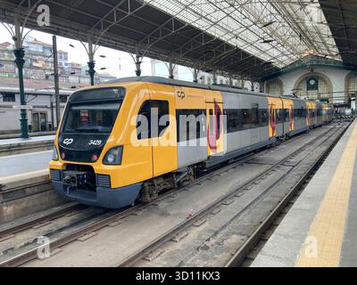 Tram della metropolitana di Porto che attraversa strade e binari nell'ambiente urbano del Portogallo. Foto Stock