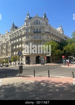 Elegante edificio storico nel centro di Madrid con un'architettura ornamentale sotto un cielo estivo azzurro. Foto Stock