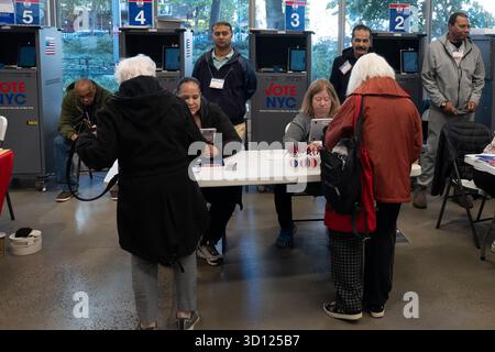 New York, Stati Uniti. 25 ottobre 2025. NEW YORK, NEW YORK - OTTOBRE 25: Gli elettori si iscrivono per votare il primo giorno di votazione anticipata a New York sul sito del sondaggio presso il Richard Gilder Center for Science, Education, and Innovation il 25 ottobre 2025 a New York. Crediti: Ron Adar/Alamy Live News Foto Stock