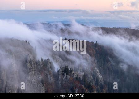 Nuvole che giocano sulle rocce di Martinsfelsen, viste da Hohneck Mountain, Vosgi, Francia. Foto Stock
