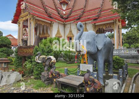Immagini rituali sculture figure di elefante indiano di fronte agli edifici del complesso monastico buddista di Wat Chalong, isola di Phuket, provincia di Phuket, T Foto Stock