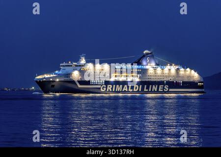 Olbia - Sardinien - Italien - 02-18-2025: Crociera Grimaldi Lines illuminata Europa naviga sul mare nei pressi di Olbia di notte, riflettendo la luce Foto Stock