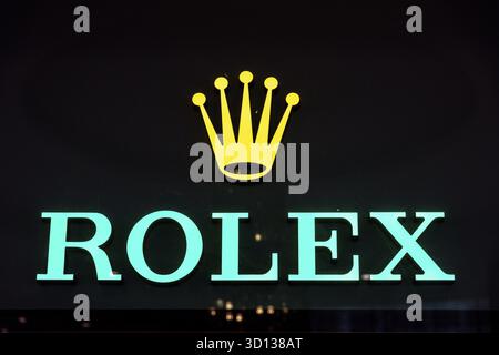 Casablanca, Casablanca-Settat - Marocco - 07-27-2024: Logo Rolex illuminato in turchese con sopra corona dorata Foto Stock