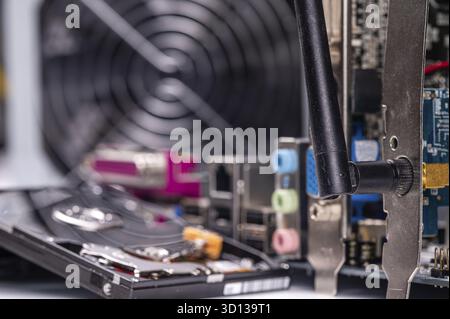 Frammento della scheda di circuito del computer con componenti sullo sfondo delle ventole dell'alimentatore sfocate Foto Stock