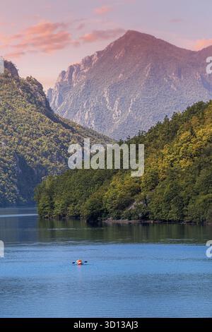 Serena vista del fiume Drina e del lago Perucac in Serbia con un kayak solitario circondato da montagne boscose al tramonto Foto Stock