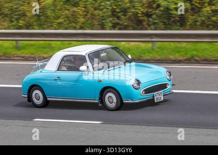 Anni '1991 90 Blue White Nissan Auto Convertible benzina 980 cc. Nissan Figaro, un'edizione limitata giapponese retro convertibile; viaggia a velocità sostenuta sull'autostrada M6, Regno Unito Foto Stock