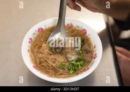 Mangiare uno spuntino Taiwan di spaghetti sottili con intestino di maiale Foto Stock