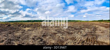 cantiere preparato con tracce di livellamento del bulldozer contro il cielo soleggiato blu in primo piano con messa a fuoco selettiva Foto Stock