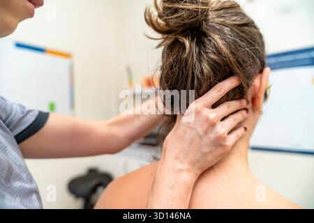 Fisioterapista che esegue la terapia manuale sul collo di un paziente in una clinica Foto Stock
