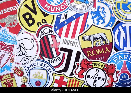 KIEV, UCRAINA - 23 FEBBRAIO 2025 molti emblemi di carta delle squadre di calcio si trovano in grande pila da vicino Foto Stock