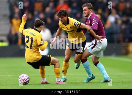 Jacob Bruun Larsen (a destra) di Burnley combatte contro Hugo Bueno (centro) dei Wolverhampton Wanderers e Rodrigo Gomes durante la partita di Premier League al Molineux Stadium di Wolverhampton. Data foto: Domenica 26 ottobre 2025. Foto Stock