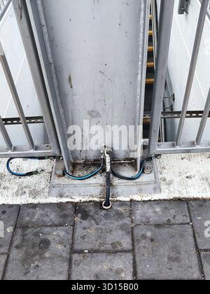 Primo piano di strutture metalliche su una piattaforma della stazione ferroviaria collegata a cavi di messa a terra, che mostrano l'impostazione della sicurezza elettrica. Ideale per costruzioni, infrazioni Foto Stock