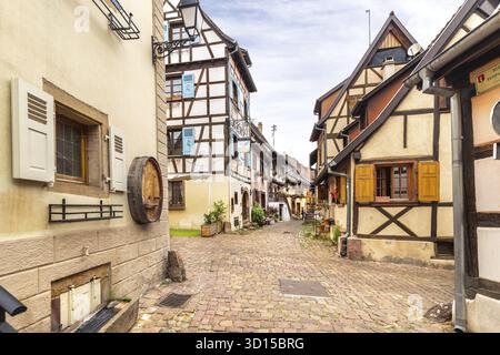 Eguisheim, Francia - 8 luglio 2019: Case colorate in legno dell'alsaziano nel villaggio di Eguisheim, Francia Foto Stock