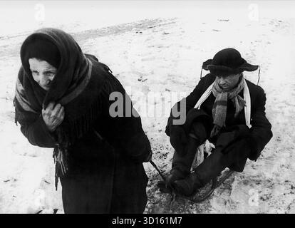 LENINGRADO, RUSSIA - 07 febbraio 1942 - una donna anziana tira con sé un uomo su una slitta durante l'assedio di Leningrado nella seconda guerra mondiale. La posizione esatta di questa fotografia non è nota, anche se potrebbe provenire dalla "strada della vita" - con la quale molti rifugiati sono fuggiti dall'assedio - foto: Geopix Foto Stock