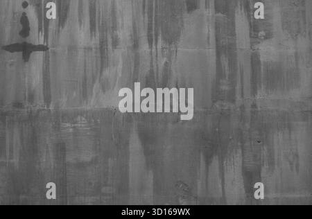 Parete di cemento grigia che presenta una superficie grintosa con striature d'acqua, consistenza ruvida e imperfezioni visibili, creando una forte grunge e dentro Foto Stock