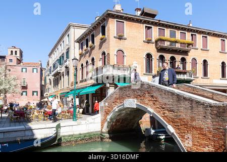 Gondoliere che si diverte a cullare gli ospiti al ristorante all'aperto in primavera, campo Santa Maria Nova, Cannaregio, Venezia, Veneto, Italia Foto Stock