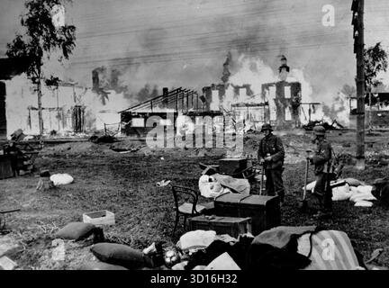 LENINGRADO, RUSSIA - circa l'8 settembre 1941 - truppe tedesche alla periferia di Leningrado, Russia. Sono circondati da possedimenti abbandonati di coloro che fuggirono durante l'avanzata tedesca mentre una chiesa brucia sullo sfondo. Le forze tedesche circondarono Leningrado l'8 settembre 1941 e così iniziarono l'assedio di Leningrado - uno degli assedi più brutali della seconda guerra mondiale - foto: Geopix/Ebert Georg Foto Stock